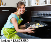 Housewife putting tray with fish in oven. Стоковое фото, фотограф Яков Филимонов / Фотобанк Лори