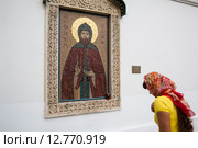 Православная верующая крестится перед образом святого благоверного великого князя Александра Невского в Свято-Даниловом мужском монастыре в городе Москве (2015 год). Редакционное фото, фотограф Николай Винокуров / Фотобанк Лори