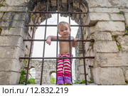 Девочка просунула голову между прутьев решетки. Стоковое фото, фотограф Михаил Кочиев / Фотобанк Лори