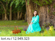 Девушка в длинном платье присела у дерева на опушке леса. Стоковое фото, фотограф Иванов Алексей / Фотобанк Лори