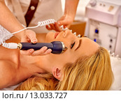 Young woman receiving electric facial massage. Стоковое фото, фотограф Gennadiy Poznyakov / Фотобанк Лори