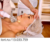Young woman receiving electric facial massage. Стоковое фото, фотограф Gennadiy Poznyakov / Фотобанк Лори