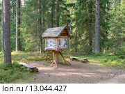 Информационная остановка со стендом в виде избушки на курьих ножках на экологической тропе «Лесные тайны» с названиями и образцами деревьев (2015 год). Редакционное фото, фотограф Pukhov K / Фотобанк Лори