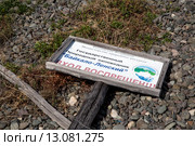Поваленный на землю информационный плакат на границе Государственного природного заповедника "Байкало-Ленский" на берегу озера Байкал, Иркутская область, Россия (2014 год). Редакционное фото, фотограф Николай Винокуров / Фотобанк Лори
