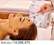 Young woman receiving electric facial massage. Стоковое фото, фотограф Gennadiy Poznyakov / Фотобанк Лори