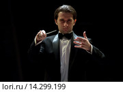 Российский дирижер Алексей Рубин дирижирует оркестром во время концерта в Большом зале Московской консерватории в центре города Москвы, Россия (2015 год). Редакционное фото, фотограф Николай Винокуров / Фотобанк Лори