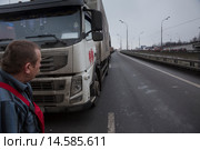 Водитель большого грузового автомобиля смотрит на движение в крайне левой полосе во время пробки на МКАД в районе Ленинградского шоссе в городе Москве, Россия (2015 год). Редакционное фото, фотограф Николай Винокуров / Фотобанк Лори