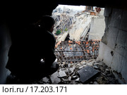 Сирийский солдат смотрит на развалины Хомса (2014 год). Редакционное фото, фотограф Кочнева Анхар / Фотобанк Лори