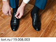Мужчина завязывает шнурки на ботинках. Стоковое фото, фотограф Игорь Низов / Фотобанк Лори