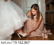 Подружка помогает одеть туфли невесте. Стоковое фото, фотограф Игорь Низов / Фотобанк Лори