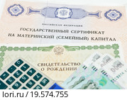 Государственный сертификат на материнский капитал, свидетельство о рождение, карманный калькулятор и тысячные купюры. Стоковое фото, фотограф Игорь Низов / Фотобанк Лори