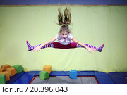 Girl is jumping high in striped tights on the big trampoline. Стоковое фото, фотограф Losevsky Pavel / Фотобанк Лори