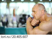 Profile of bodybuilder basing on fitness equipment in gym hall. Стоковое фото, фотограф Losevsky Pavel / Фотобанк Лори