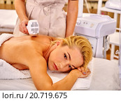 Young woman receiving electric back massage. Стоковое фото, фотограф Gennadiy Poznyakov / Фотобанк Лори