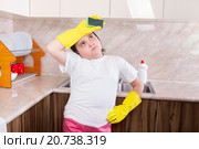 Девочка   с губкой в руках измучилась  от домашней работы на кухне. Стоковое фото, фотограф Emelinna / Фотобанк Лори