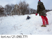 Молодые люди катаются на ватрушках и ледянках с крутой горки в снежную зиму в парке города Москвы, Россия (2016 год). Редакционное фото, фотограф Николай Винокуров / Фотобанк Лори