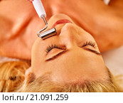 Young woman receiving electric facial massage. Стоковое фото, фотограф Gennadiy Poznyakov / Фотобанк Лори