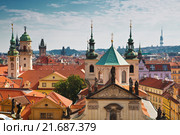 View of the roofs of Prague, with red tiled roofs and  statues, spires and towers protruding (2014 год). Стоковое фото, фотограф Наталья Волкова / Фотобанк Лори