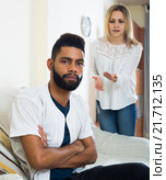 Blonde girl yelling at black boyfriend as quarreling indoors. Стоковое фото, фотограф Яков Филимонов / Фотобанк Лори