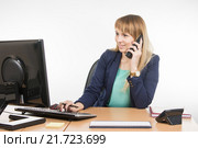 Деловая девушка работает в компьютере и разговаривает по телефону. Стоковое фото, фотограф Иванов Алексей / Фотобанк Лори