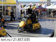 Мужчина тестирует двухроторную затирочную машину Wacker Neuson CRT 48 на залитом бетоне на выставке World of Concrete 2016. Редакционное фото, фотограф Роман Коротков / Фотобанк Лори