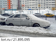 Занесенный снегом старый автомобиль ВАЗ-2112 стоит во дворе дома (2016 год). Редакционное фото, фотограф Александр Замараев / Фотобанк Лори