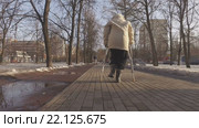 Пожилая женщина на костылях в городском парке весной (2016 год). Редакционное видео, видеограф Серёга / Фотобанк Лори