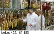 Technologist with butcher checking drying wurst and jamon at factory. Стоковое видео, видеограф Яков Филимонов / Фотобанк Лори