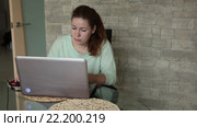 Женщина работает на нотбуке, стоящем на стеклянном столе на кухне. Стоковое видео, видеограф Кекяляйнен Андрей / Фотобанк Лори