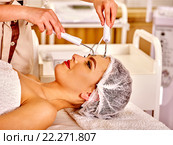Young woman receiving electric facial massage. Стоковое фото, фотограф Gennadiy Poznyakov / Фотобанк Лори