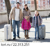 Family portrait of travellers with wheeled trollers in spring day. Стоковое фото, фотограф Яков Филимонов / Фотобанк Лори
