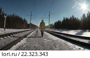 Женщина в зимней одежде идет на камеру и от камеры в другую сторону, зима, железная дорога. Стоковое видео, видеограф Кекяляйнен Андрей / Фотобанк Лори
