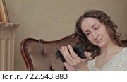 Русоволосая девушка с смартфоном на диване. Стоковое видео, видеограф Aleksey Popov / Фотобанк Лори
