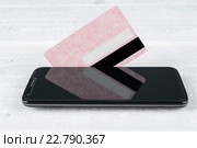 Кредитная карта и смартфон на деревянном столе. Стоковое фото, фотограф Рамиль Гибадуллин / Фотобанк Лори