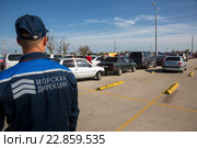 Сотрудник Керченской паромной переправы пропускает автомобили в порт Кавказ на косе Чушка в Темрюкском районе Краснодарского края, Россия (2016 год). Редакционное фото, фотограф Николай Винокуров / Фотобанк Лори