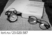 Часы-будильник "Ракета" (СССР), очки и книга (2016 год). Редакционное фото, фотограф Покровский Артур / Фотобанк Лори