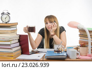 Девушка студентка грустно посмотрела в кадр сидя с чашкой кофе в руках. Стоковое фото, фотограф Иванов Алексей / Фотобанк Лори