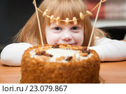 Улыбающаяся девочка, желающая съесть торт Медовик, декорированный орехами, сухофруктами и печеньем-рыбками. Стоковое фото, фотограф Evgenia Shevardina / Фотобанк Лори