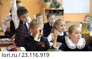 Дети школьники тянут руки на уроке для ответа на вопрос (2016 год). Редакционное видео, видеограф Кекяляйнен Андрей / Фотобанк Лори