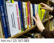 Читатель в библиотеке выбирает книги о правильном питании (2016 год). Редакционное фото, фотограф Вячеслав Палес / Фотобанк Лори