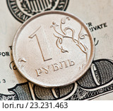 Монетка номиналом в 1 рубль на фоне банкноты в 100 долларов. Стоковое фото, фотограф E. O. / Фотобанк Лори