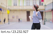 Девушка туристка с напитком в стакане гуляет по европейскому городу. Стоковое видео, видеограф Дмитрий Травников / Фотобанк Лори