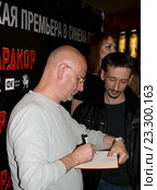 Известный переводчик Дмитрий Пучков подписывает книгу поклоннику (2016 год). Редакционное фото, фотограф Данила Васильев / Фотобанк Лори