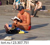Мужчина загорает и читает книгу (2016 год). Редакционное фото, фотограф Павел Кулинич / Фотобанк Лори