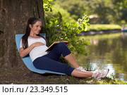 Young pregnant woman with book sits in the park. Стоковое фото, фотограф Мельников Дмитрий / Фотобанк Лори