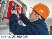 electrician with screwdriver repair switching electric actuator in fuse box. Стоковое фото, фотограф Дмитрий Калиновский / Фотобанк Лори