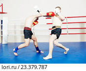 Muay thai sportsman fighting at boxing ring. Стоковое фото, фотограф Дмитрий Калиновский / Фотобанк Лори