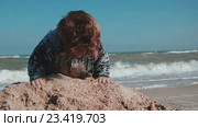 Двухлетний мальчик играет в куче песка на фоне моря. Стоковое видео, видеограф Сергей Мнацаканов / Фотобанк Лори