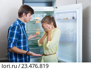 Frustraited starving female and man near fridge without any food. Стоковое фото, фотограф Яков Филимонов / Фотобанк Лори