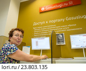 Пожилая женщина пользуется терминалом для доступа к порталу "Госулуги" в центре "Мои документы" (2016 год). Редакционное фото, фотограф Вячеслав Палес / Фотобанк Лори